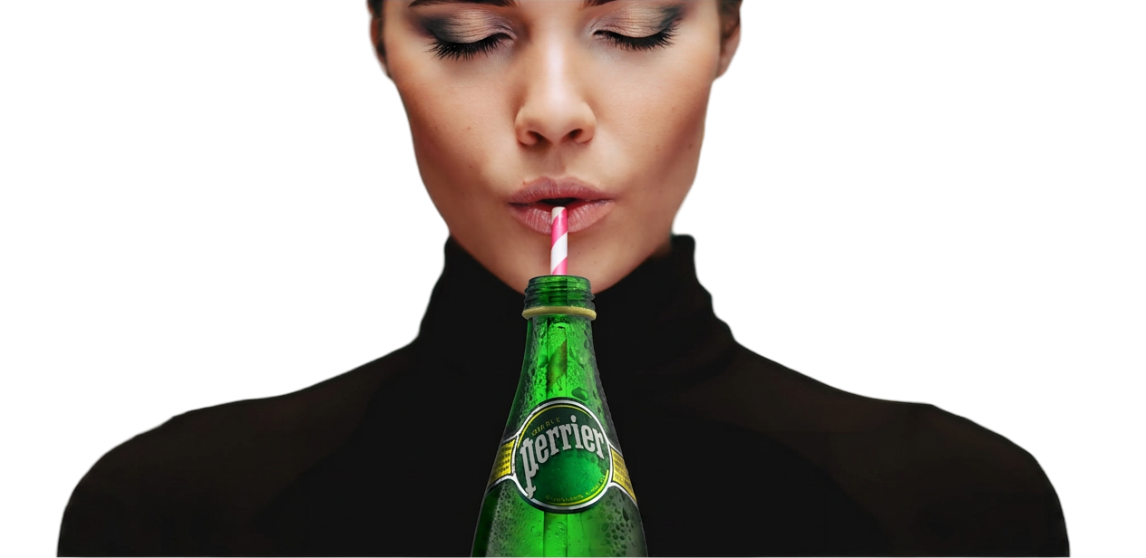 Person drinking from a green glass bottle with a striped straw